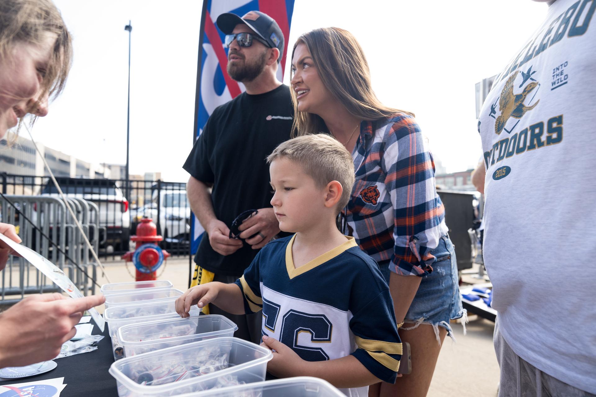Fans collect NASA pins outside the NASA Experience Zone at an NFL game between the Pittsburgh Steelers and the Atlanta Falcons at Acrisure Stadium, Sunday, Sept. 13, 2026, in Pittsburgh, Pennsylvania. NASA’s engagement at NFL games is part of the agency's Inspiration Tour, aimed at strengthening connections between NASA and its partners and showcasing innovation in air and space in the lead up to the MAX POWER aerospace technology expo and airshow at the agency's Kennedy Space Center in early November. Photo Credit: (NASA/Aubrey Gemignani)