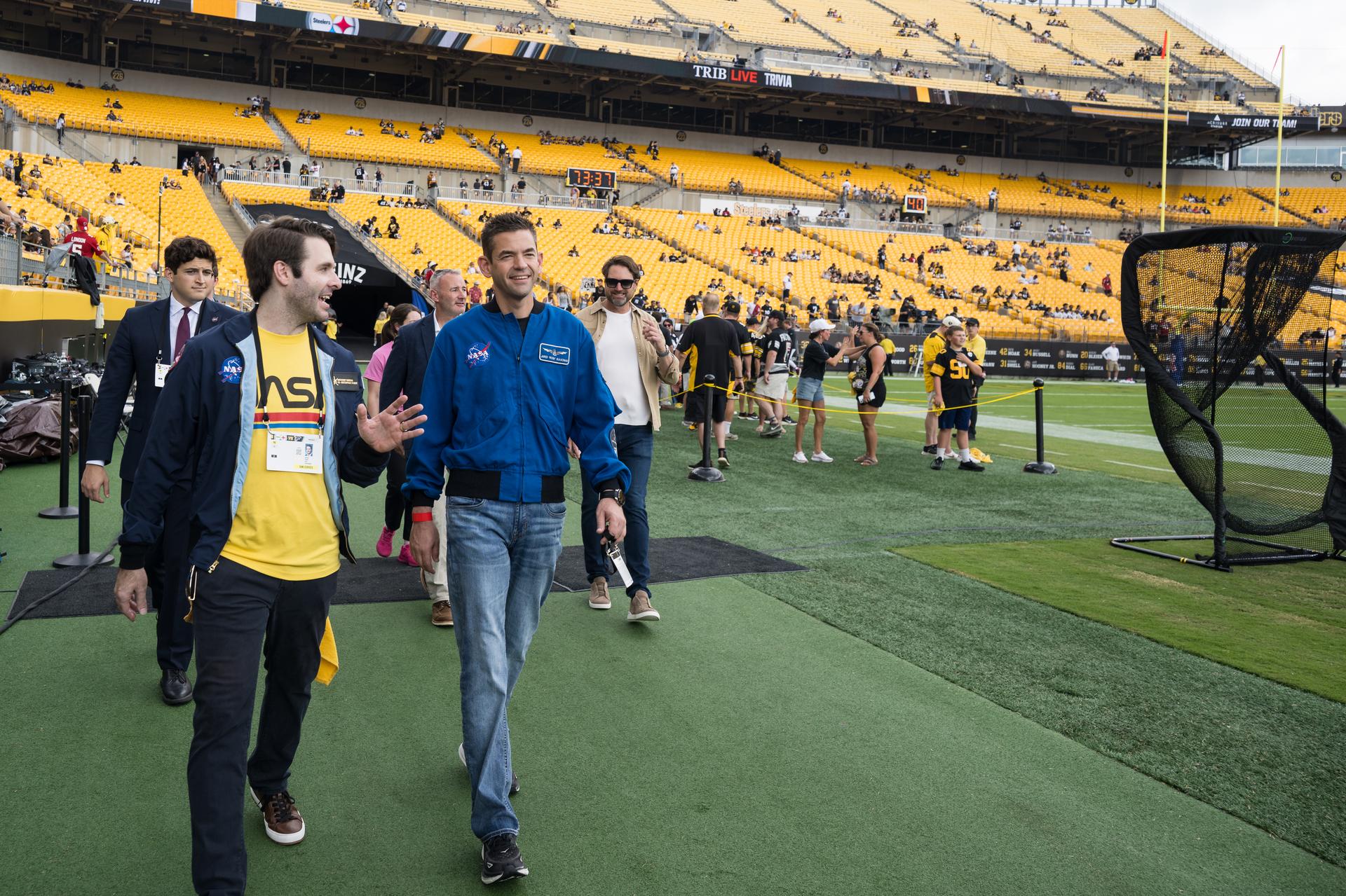 NASA Administrator Jared Isaacman, right, and NASA flight director Anthony Vareha, left walk along the sidelines at an NFL game between the Pittsburgh Steelers and the Atlanta Falcons at Acrisure Stadium, Sunday, Sept. 13, 2026, in Pittsburgh, Pennsylvania. NASA’s engagement at NFL games is part of the agency's Inspiration Tour, aimed at strengthening connections between NASA and its partners and showcasing innovation in air and space in the lead up to the MAX POWER aerospace technology expo and airshow at the agency's Kennedy Space Center in early November. Photo Credit: (NASA/Aubrey Gemignani)