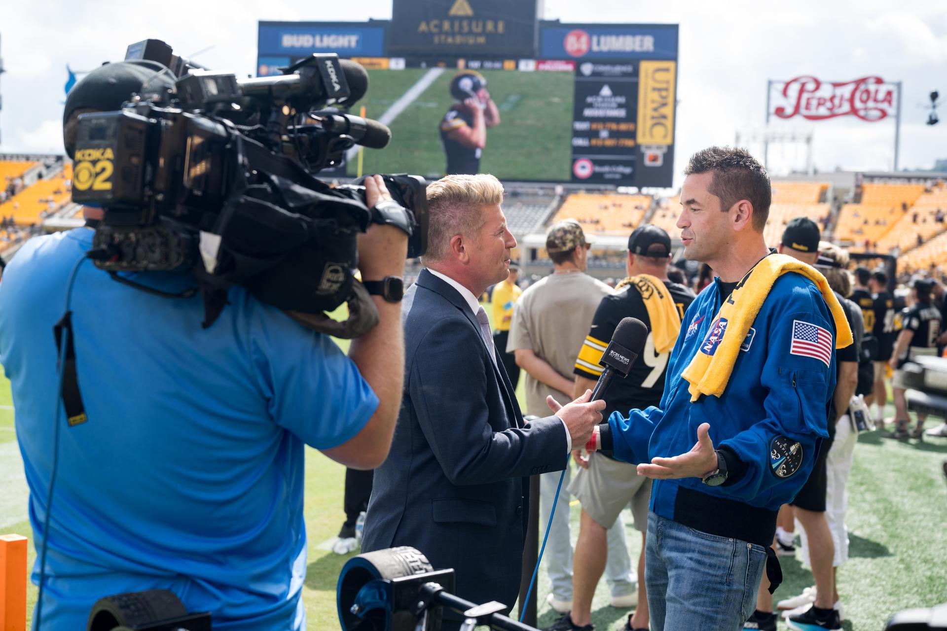NASA Administrator Jared Isaacman is interviewed by media at an NFL game between the Pittsburgh Steelers and the Atlanta Falcons at Acrisure Stadium, Sunday, Sept. 13, 2026, in Pittsburgh, Pennsylvania. NASA’s engagement at NFL games is part of the agency's Inspiration Tour, aimed at strengthening connections between NASA and its partners and showcasing innovation in air and space in the lead up to the MAX POWER aerospace technology expo and airshow at the agency's Kennedy Space Center in early November. Photo Credit: (NASA/Aubrey Gemignani)