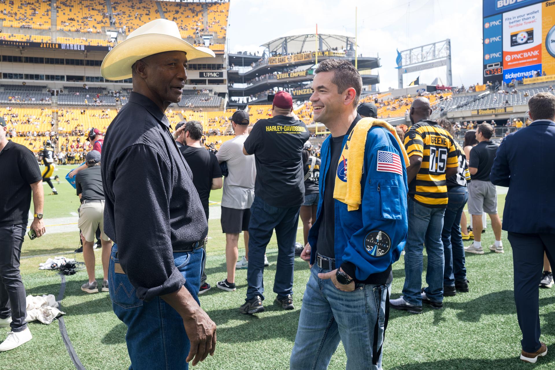 NASA Administrator Jared Isaacman right, speaks with Mel Blount, former Pittsburgh Steelers professional football player at an NFL game between the Pittsburgh Steelers and the Atlanta Falcons at Acrisure Stadium, Sunday, Sept. 13, 2026, in Pittsburgh, Pennsylvania. NASA’s engagement at NFL games is part of the agency's Inspiration Tour, aimed at strengthening connections between NASA and its partners and showcasing innovation in air and space in the lead up to the MAX POWER aerospace technology expo and airshow at the agency's Kennedy Space Center in early November. Photo Credit: (NASA/Aubrey Gemignani)
