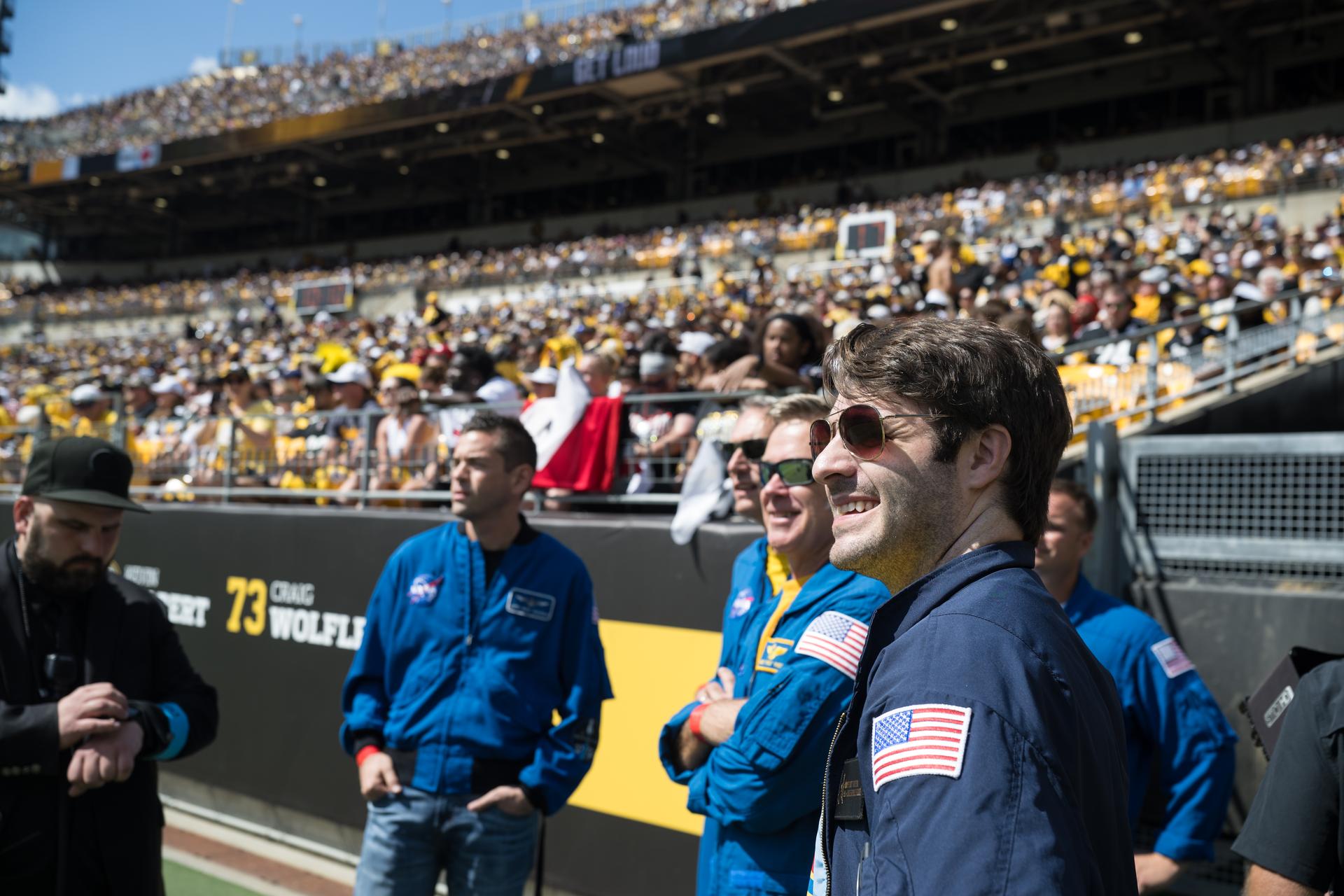 NASA Administrator Jared Isaacman, left, and NASA Flight Director Anthony Vareha, right, wait on the field with the flyover team, pilots Brett Pugsley, Chris Condon, and co-pilot Geoff Palmer, as well as NASA Ground Liaison Brad Nesmith and Rufus Brennemen, before they are featured on the Jumbotron at an NFL game between the Pittsburgh Steelers and the Atlanta Falcons at Acrisure Stadium, Sunday, Sept. 13, 2026, in Pittsburgh, Pennsylvania. NASA’s engagement at NFL games is part of the agency's Inspiration Tour, aimed at strengthening connections between NASA and its partners and showcasing innovation in air and space in the lead up to the MAX POWER aerospace technology expo and airshow at the agency's Kennedy Space Center in early November. Photo Credit: (NASA/Aubrey Gemignani)