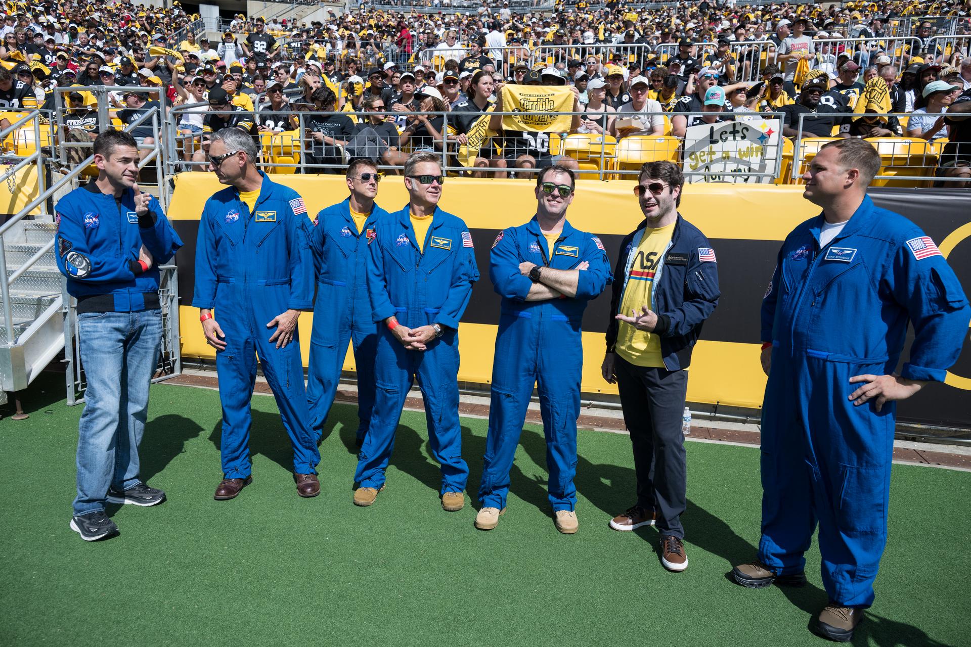 From left to right, NASA Administrator Jared Isaacman, Geoff Palmer, NASA Co-Pilot, Chris Condon, NASA Wing Pilot, Brett Pugsley, NASA Lead Pilot, Brad Nesmith, NASA Ground Liaison, Anthony Vareha, NASA Flight Director, and Rufus Brennemen, NASA Ground Liaison pose for a photo before they participate in a call back on the sidelines after conducting a flyover at an NFL game between the Pittsburgh Steelers and the Atlanta Falcons at Acrisure Stadium, Sunday, Sept. 13, 2026, in Pittsburgh, Pennsylvania. NASA’s engagement at NFL games is part of the agency's Inspiration Tour, aimed at strengthening connections between NASA and its partners and showcasing innovation in air and space in the lead up to the MAX POWER aerospace technology expo and airshow at the agency's Kennedy Space Center in early November. Photo Credit: (NASA/Aubrey Gemignani)