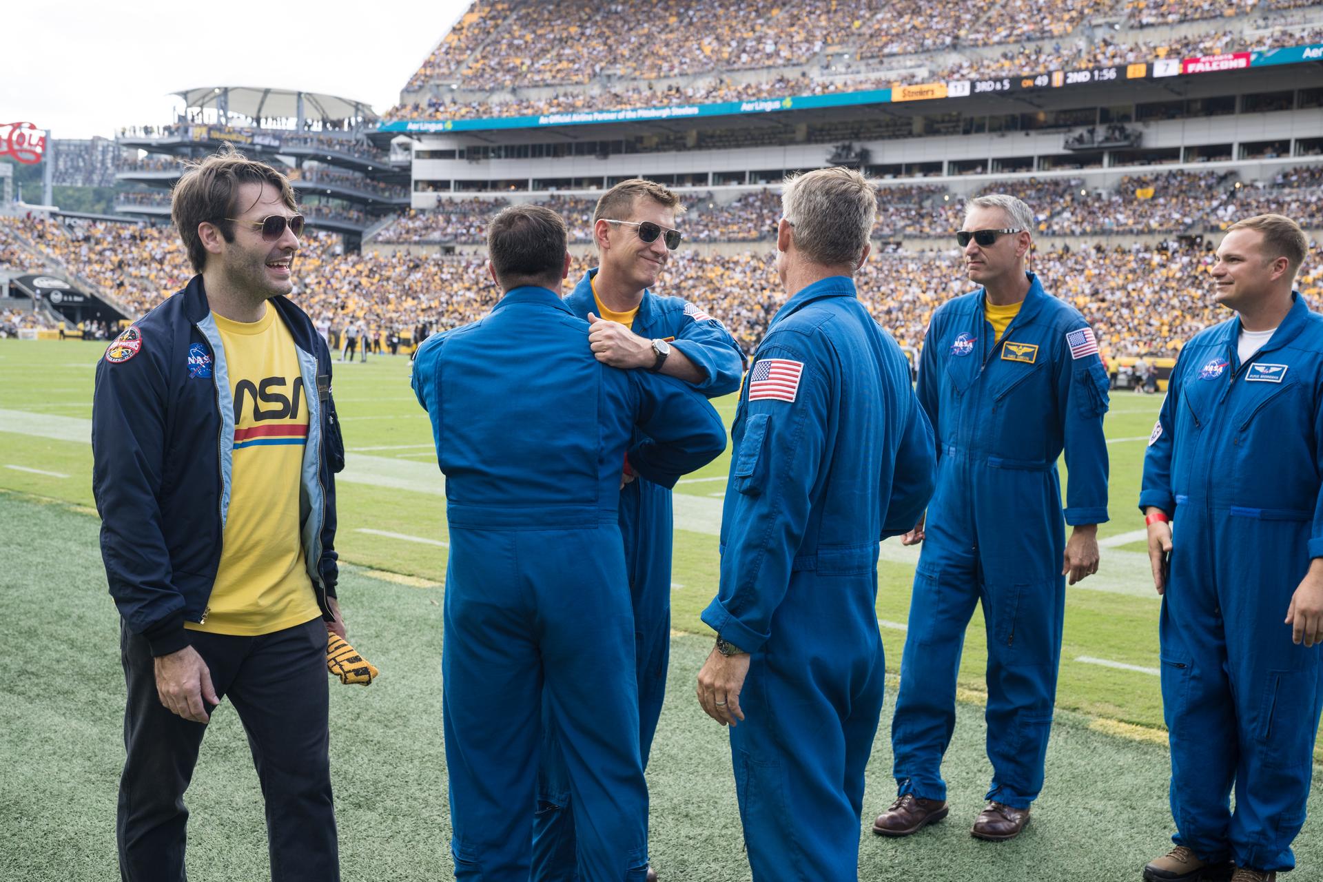 Geoff Palmer, NASA Co-Pilot, third from left, and Brad Nesmith, NASA Ground Liaison, second from left, hug after they participated in a call-back after Brett Pugsley, NASA Lead Pilot, fourth from left, Chris Condon, NASA Wing Pilot, fifth from left, and Palmer conducted a flyover at an NFL game between the Pittsburgh Steelers and the Atlanta Falcons at Acrisure Stadium, Sunday, Sept. 13, 2026, in Pittsburgh, Pennsylvania. NASA’s engagement at NFL games is part of the agency's Inspiration Tour, aimed at strengthening connections between NASA and its partners and showcasing innovation in air and space in the lead up to the MAX POWER aerospace technology expo and airshow at the agency's Kennedy Space Center in early November. Photo Credit: (NASA/Aubrey Gemignani)