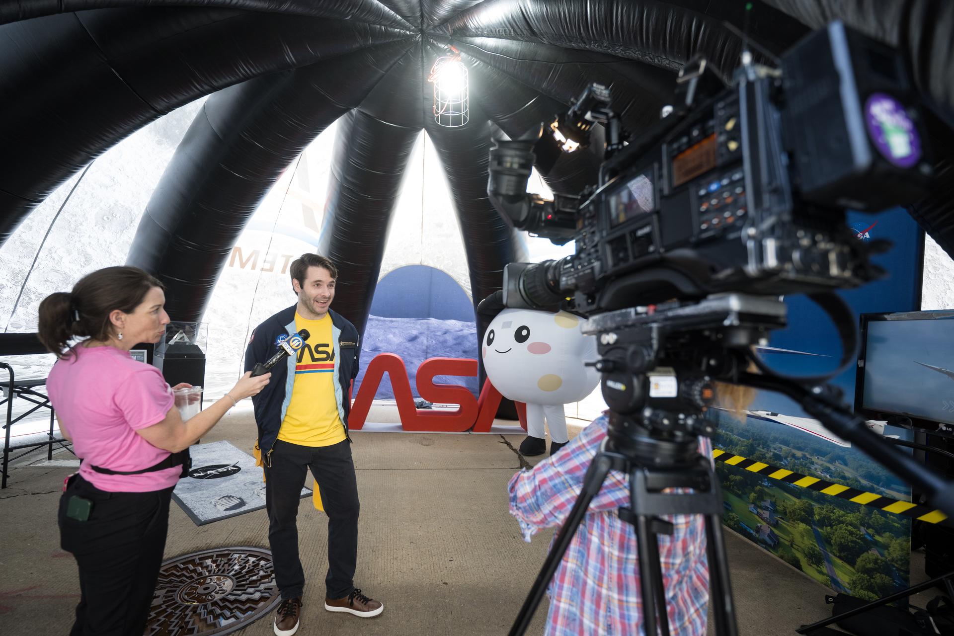 Anthony Vareha, NASA Flight Director at NASA’s Johnson Space Center is interviewed by media in the NASA Experience Zone at an NFL game between the Pittsburgh Steelers and the Atlanta Falcons at Acrisure Stadium, Sunday, Sept. 13, 2026, in Pittsburgh, Pennsylvania. NASA’s engagement at NFL games is part of the agency's Inspiration Tour, aimed at strengthening connections between NASA and its partners and showcasing innovation in air and space in the lead up to the MAX POWER aerospace technology expo and airshow at the agency's Kennedy Space Center in early November. Photo Credit: (NASA/Aubrey Gemignani)