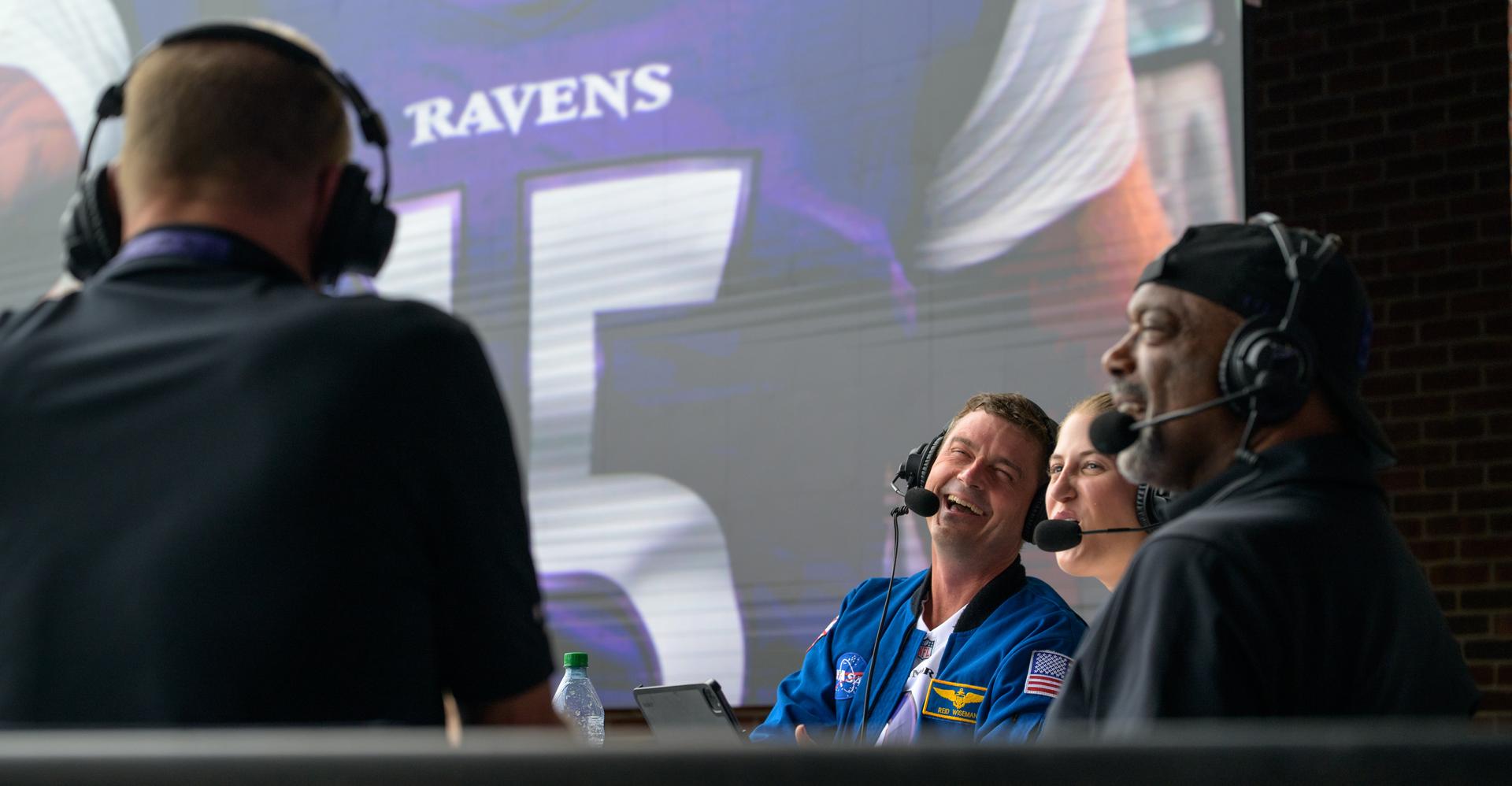 NASA astronaut and commander of the agency’s Artemis II mission, Reid Wiseman, a Baltimore native, is seen during an WBAL radio interview prior to the start of an NFL game between the New Orleans Saints and the Baltimore Ravens at M&T Bank Stadium, Sunday, Sept. 20, 2026, in Baltimore. NASA’s engagement at NFL games is part of the agency's Inspiration Tour, aimed at strengthening connections between NASA and its partners and showcasing innovation in air and space in the lead up to the MAX POWER aerospace technology expo and airshow at the agency's Kennedy Space Center in early November. Photo Credit: (NASA/Bill Ingalls)