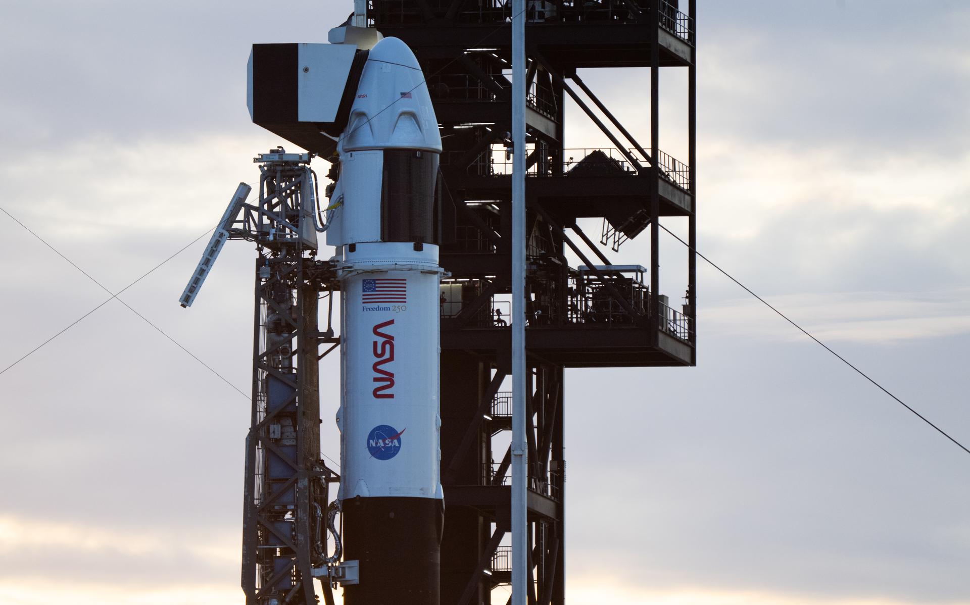 A SpaceX Falcon 9 rocket with the company's Dragon spacecraft on top is seen at sunset on the launch pad at Space Launch Complex 40 as preparations continue for the Crew-13 mission, Wednesday, Sept. 30, 2026, at Cape Canaveral Space Force Station in Florida. NASA’s SpaceX Crew-13 mission is the 13th crew rotation mission of the SpaceX Dragon spacecraft and Falcon 9 rocket to the International Space Station as part of the agency’s Commercial Crew Program. NASA astronauts Jessica Watkins and Luke Delaney, CSA (Canadian Space Agency) astronaut Joshua Kutryk, and Roscosmos cosmonaut Sergey Teteryatnikov are scheduled to launch at 11:10 a.m. EDT on Thursday, Oct. 1, from Space Launch Complex 40 at the Cape Canaveral Space Force Station. Photo Credit: (NASA/Joel Kowsky)