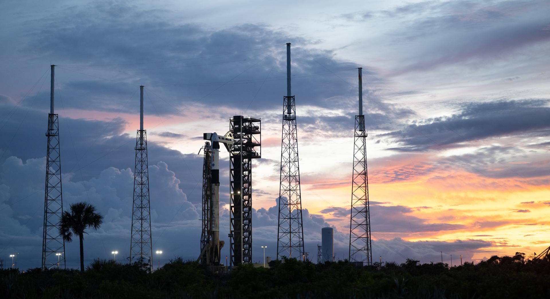 A SpaceX Falcon 9 rocket with the company's Dragon spacecraft on top is seen at sunset on the launch pad at Space Launch Complex 40 as preparations continue for the Crew-13 mission, Wednesday, Sept. 30, 2026, at Cape Canaveral Space Force Station in Florida. NASA’s SpaceX Crew-13 mission is the 13th crew rotation mission of the SpaceX Dragon spacecraft and Falcon 9 rocket to the International Space Station as part of the agency’s Commercial Crew Program. NASA astronauts Jessica Watkins and Luke Delaney, CSA (Canadian Space Agency) astronaut Joshua Kutryk, and Roscosmos cosmonaut Sergey Teteryatnikov are scheduled to launch at 11:10 a.m. EDT on Thursday, Oct. 1, from Space Launch Complex 40 at the Cape Canaveral Space Force Station. Photo Credit: (NASA/Joel Kowsky)