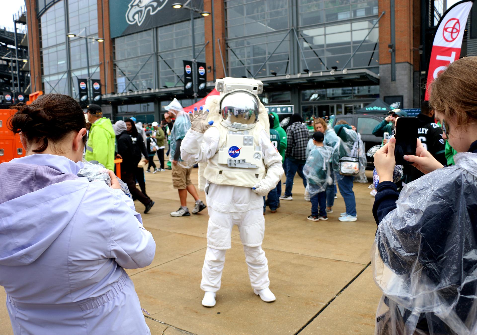 Fans take photos of the astronaut at the NASA activation at the NFL game between the Philadelphia Eagles and the Los Angeles Rams at Lincoln Financial Field on Sunday, Oct. 4, 2026, in Philadelphia. NASA’s engagement at NFL games is part of the agency's Inspiration Tour, aimed at strengthening connections between NASA and its partners and showcasing innovation in air and space in the lead up to the MAX POWER aerospace technology expo and airshow at the agency's Kennedy Space Center in early November. Photo Credit: (NASA/Thalia Patrinos)