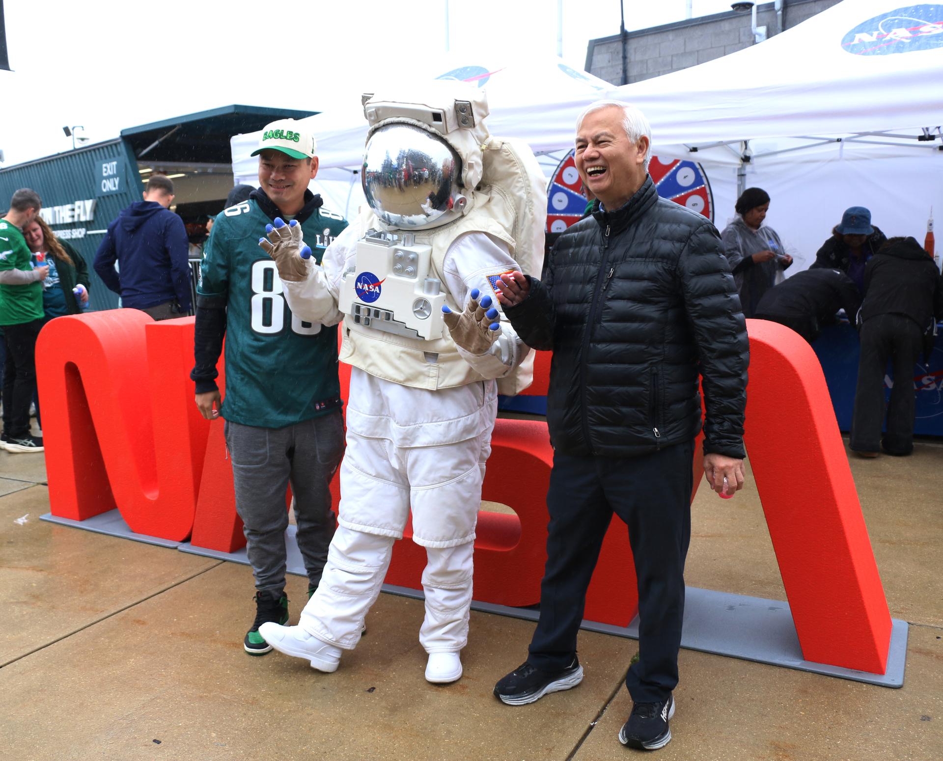 Fans pose with the astronaut at the NASA activation at the NFL game between the Philadelphia Eagles and the Los Angeles Rams at Lincoln Financial Field on Sunday, Oct. 4, 2026, in Philadelphia. NASA’s engagement at NFL games is part of the agency's Inspiration Tour, aimed at strengthening connections between NASA and its partners and showcasing innovation in air and space in the lead up to the MAX POWER aerospace technology expo and airshow at the agency's Kennedy Space Center in early November. Photo Credit: (NASA/Thalia Patrinos)