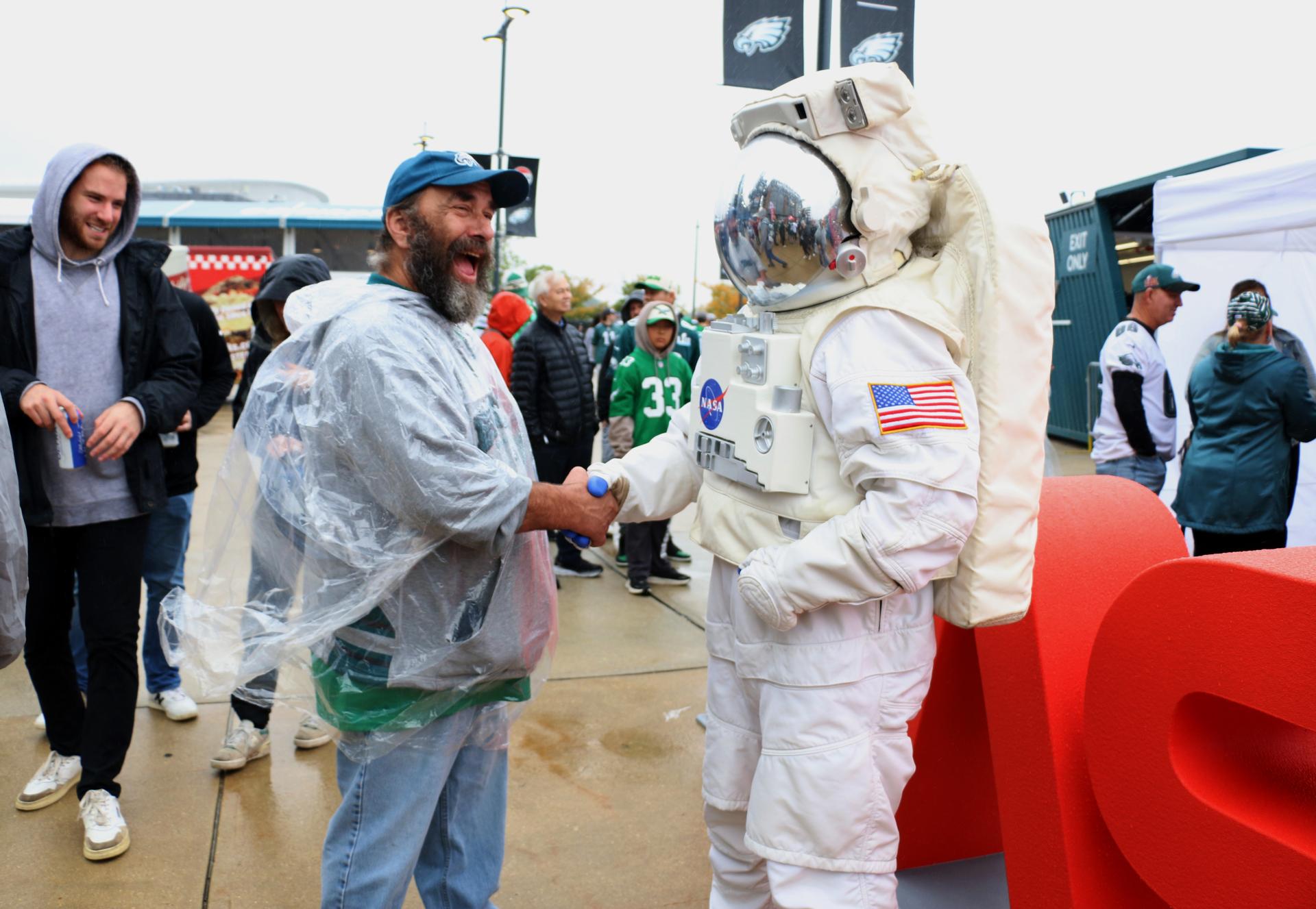 A fan greets the astronaut at the NASA activation at the NFL game between the Philadelphia Eagles and the Los Angeles Rams at Lincoln Financial Field on Sunday, Oct. 4, 2026, in Philadelphia. NASA’s engagement at NFL games is part of the agency's Inspiration Tour, aimed at strengthening connections between NASA and its partners and showcasing innovation in air and space in the lead up to the MAX POWER aerospace technology expo and airshow at the agency's Kennedy Space Center in early November. Photo Credit: (NASA/Thalia Patrinos)