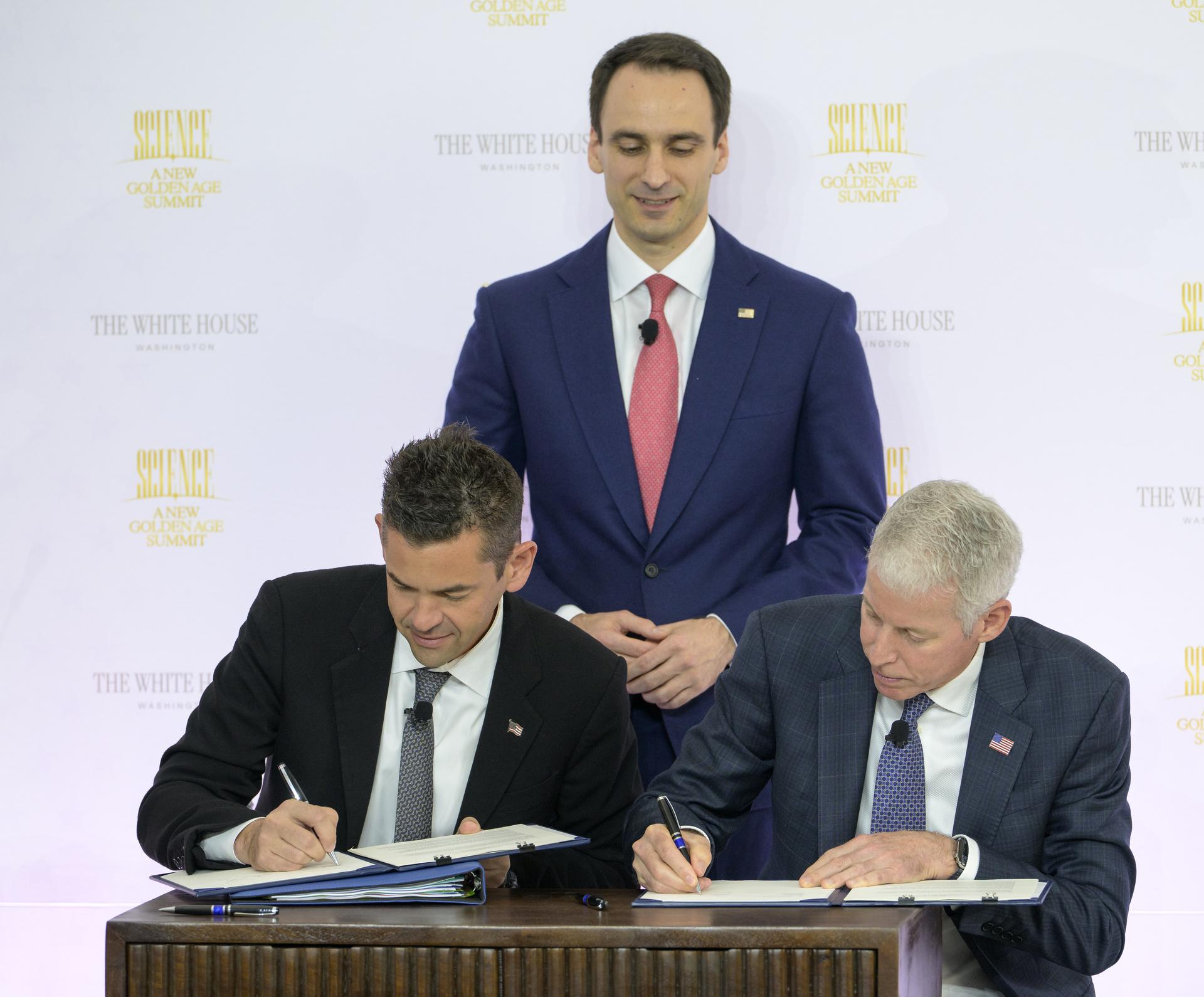 NASA Administrator Jared Isaacman, seated left, and U.S. Secretary of Energy Chris Wright, seated right, sign a new Memorandum of Understanding, “Accelerating American Leadership in Space Nuclear Power and Propulsion”, as Director of the White House Office of Science and Technology Policy (OSTP) Michael Kratsios, looks on, during the Golden Age Summit, Thursday, Oct. 8, 2026, at the Donald J. Trump Institute of Peace in Washington. Photo Credit: (NASA/Bill Ingalls)