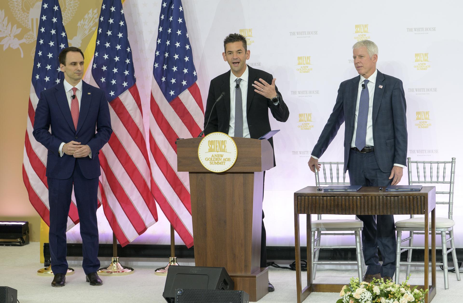 NASA Administrator Jared Isaacman, center, gives remarks with Director of the White House Office of Science and Technology Policy (OSTP) Michael Kratsios, left, and U.S. Secretary of Energy Chris Wright, ahead of NASA and DOE signing a new Memorandum of Understanding, “Accelerating American Leadership in Space Nuclear Power and Propulsion”, during the Golden Age Summit, Thursday, Oct. 8, 2026, at the Donald J. Trump Institute of Peace in Washington. Photo Credit: (NASA/Bill Ingalls)