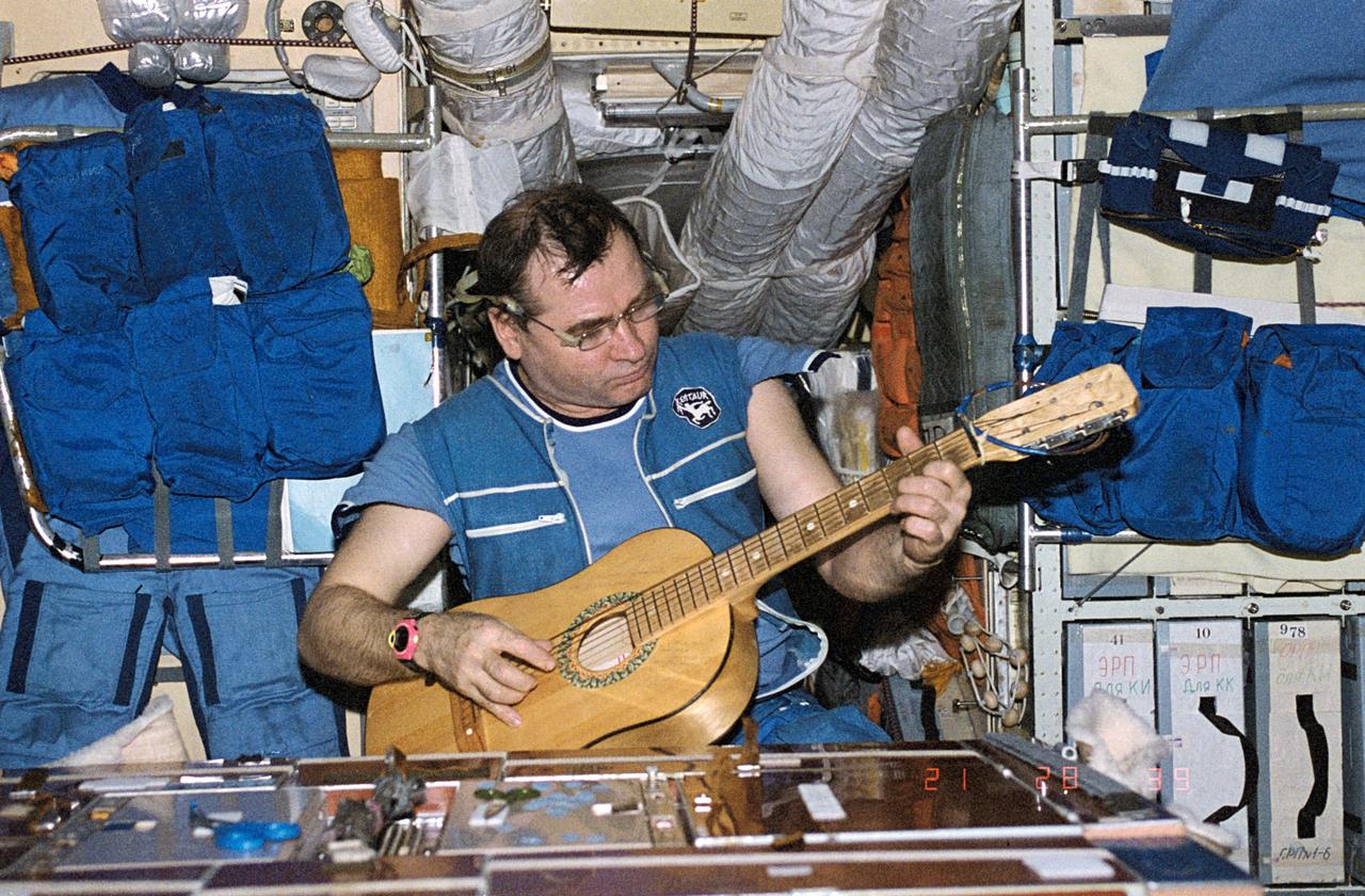 NM18-303-025 (March-July 1995) --- Onboard Mir&#0146;s base block module, cosmonaut Gennadiy M. Strekalov finds a rare moment of relaxation.  At a July 18 press conference in Houston, Strekalov told reporters the guitar had been aboard the Space Station for several years.