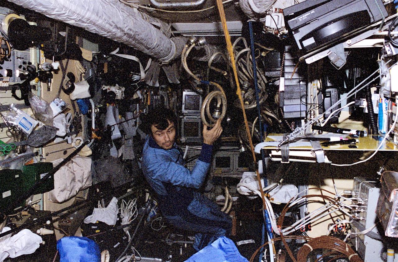 NM18-307-014 (March-July 1995) --- Onboard Mir's Spektr module, cosmonaut Vladimir N. Dezhurov re-routes cables as part of the module's activation process. This visual was one of many shown by the Mir-18 crew at a press conference on July 18 in Houston.