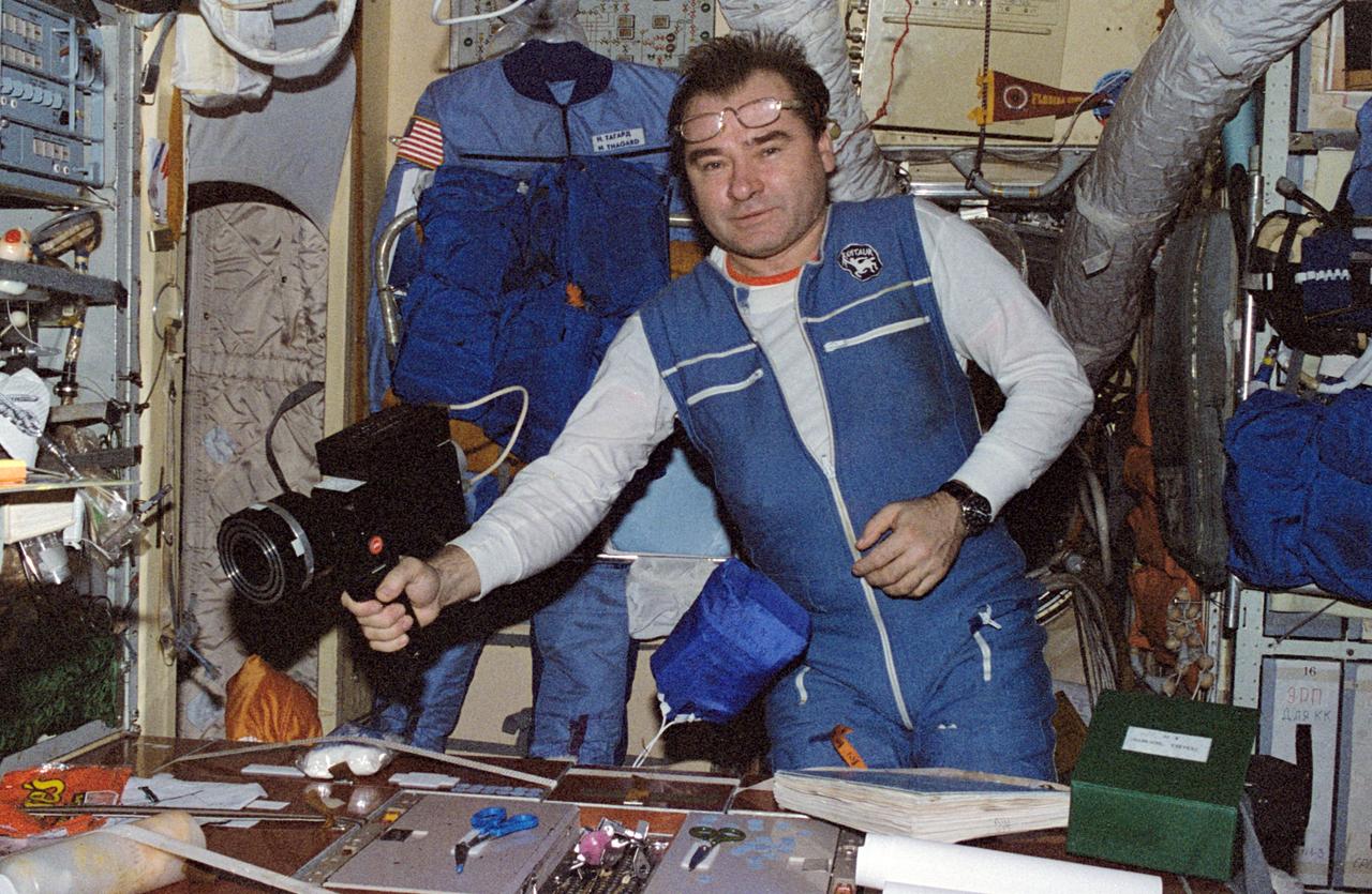 NM18-308-001 (March-July 1995) --- Onboard Mir's base block module, cosmonaut Gennadiy M. Strekalov, uses a hand held device to check the air. He stands near the table used for a great variety of activity--from eating, to chart-making, to hosting onboard press conferences. This visual was one of many shown by the Mir-18 crew at a press conference on July 18 in Houston.