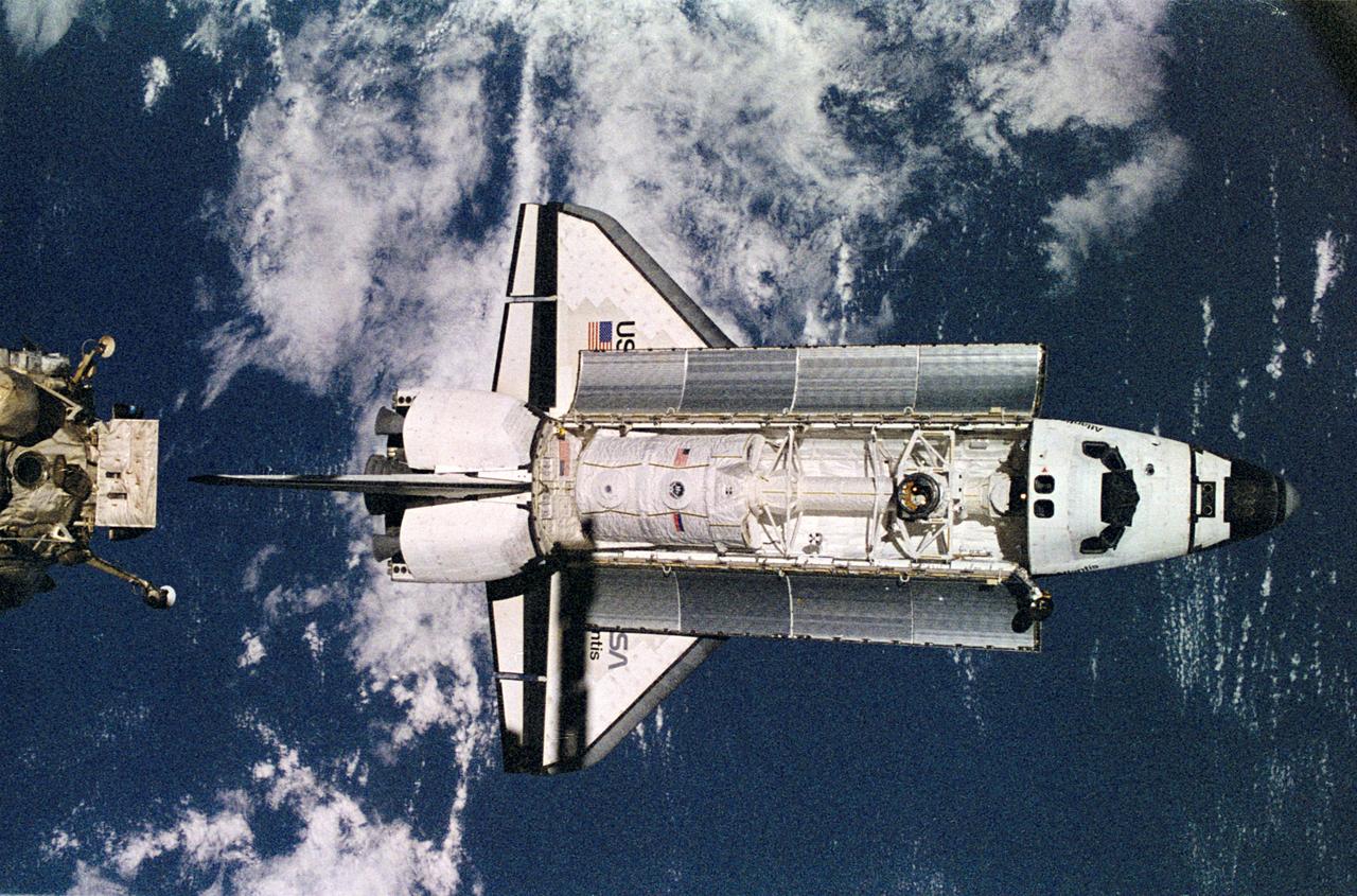 NM18-309-028 (28 June 1995) --- The Space Shuttle Atlantis approaches the docking node on the Kristall module of Russia's Mir Space Station.  The photograph was taken by one of the Mir-18 crew members aboard Mir prior to docking of the two spacecraft. The Spacelab science module and the tunnel connecting it to the crew cabin, as well as the added mechanism for interface with the Mir's docking system can be easily seen.