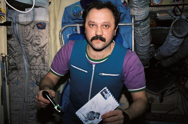 NASA image: Mir 21 flight engineer unpacks food for a meal