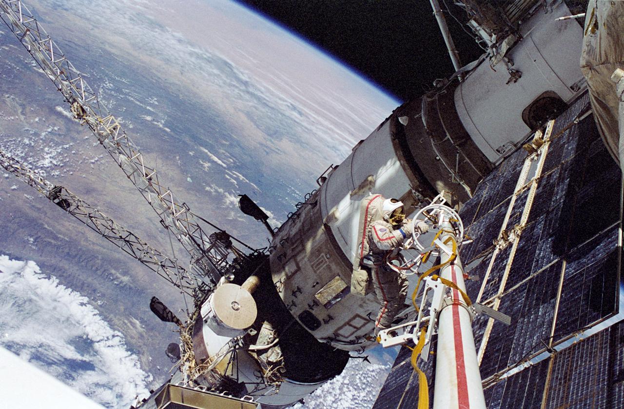 NM23-48-003 (29 April 1997) --- Cosmonaut Vasili V. Tsibliyev, Mir-23 commander, operates at the end of the Russian Mir Space Station’s STRELA boom during a space walk on April 29, 1997. He was joined by United States astronaut Jerry M. Linenger, cosmonaut guest researcher, in an effort to deploy scientific instruments and retrieve other science hardware. At the lower left of the picture is the Kvant-1 module. Hovering above it is the Sofora tower, which was once used for an experiment in attitude control of the Mir.