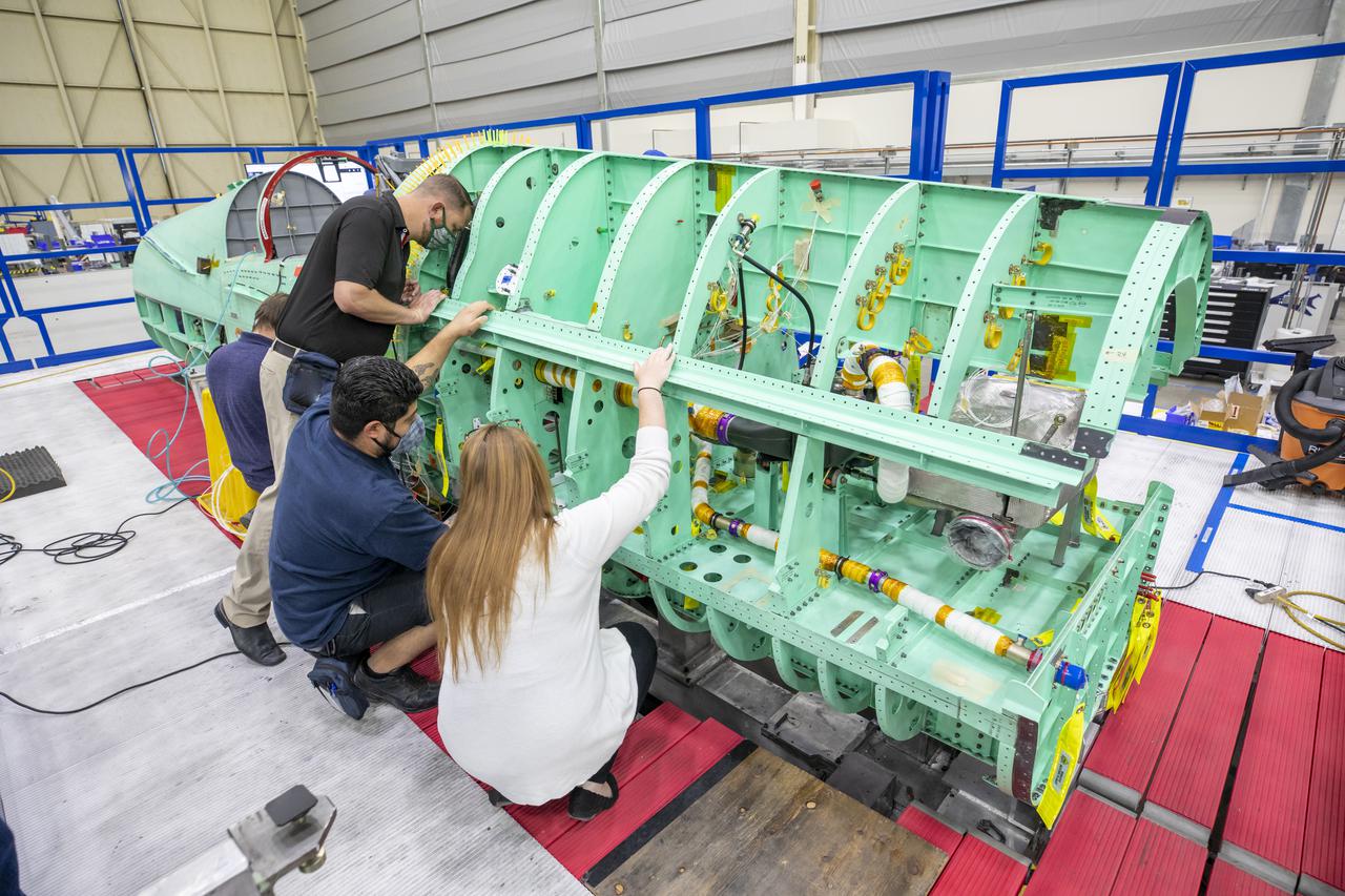 Technicians are shown here working on the X-59 fuselage section of the aircraft. The fuselage contains the cockpit and helps define the distinct shape of the X-59.  Lockheed Martin Photography By Garry Tice 1011 Lockheed Way, Palmdale, Ca. 93599 Event: SEG 210 Forebody-Subsystems Date: 5/12/2021