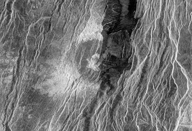 This radar image from NASA's Magellan spacecraft is of a half crater located in the rift between Rhea and Theia Montes in Beta Regio on Venus and has been cut by many fractures or faults since it was formed by the impact of a large asteroid. http://photojournal.jpl.nasa.gov/catalog/PIA00100