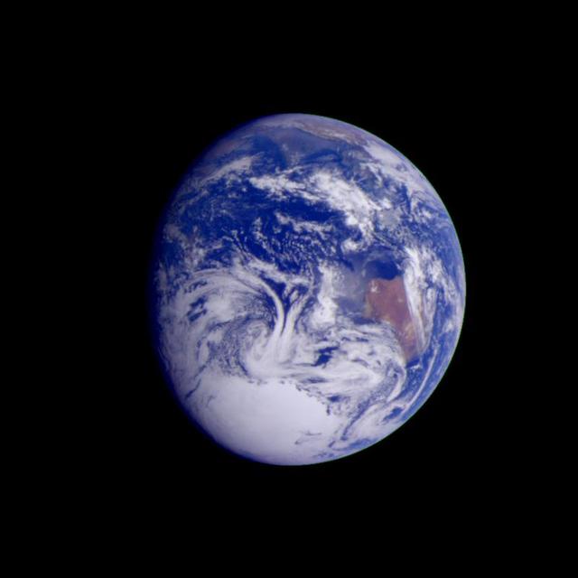 Earth seen from space with land, oceans, and clouds visible.