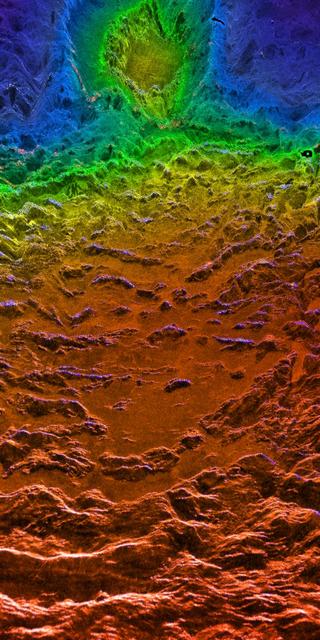 This perspective view of Venus, generated by computer from NASA Magellan data and color-coded with emissivity, is a look westward across the Fortuna Tessera toward the slopes of Maxwell Montes. http://photojournal.jpl.nasa.gov/catalog/PIA00315