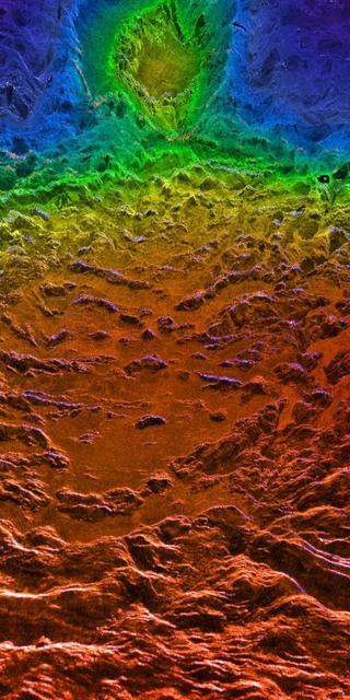This perspective view of Venus, generated by computer from NASA Magellan data and color-coded with emissivity, is a look westward across the Fortuna Tessera toward the slopes of Maxwell Montes. http://photojournal.jpl.nasa.gov/catalog/PIA00316