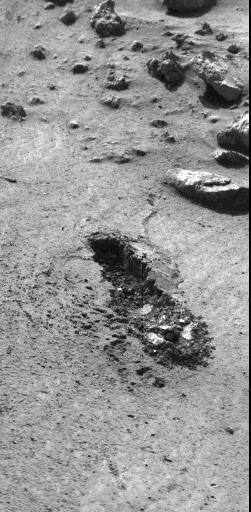 This image, received today, shows the trench excavated by NASA's Viking 1 surface sampler. The trench was dug by extending the surface sampler collection head in a direction from lower right toward the upper left and then withdrawing the surface sampler collector head. Lumpy piles of material at end of trench at lower right was pulled by plowing from trench by the backhoe which will be used to dig trenches later in the mission. Area around trench has ripple marks produced by Martian wind. The trench which was dug early on Sol 8, is about 3 inches wide, 2 inches deep and 6 inches long. Steep dark crater walls show the grains of the Martian surface material stick together (have adhesion). The doming of the surface at far end of the trench show the granular material is dense. The Martian surface material behaves somewhat like moist sand on Earth. Evidence from the trench indicate a sample was collected and delivered to the experiments after repeated tries. The biology experiment level full indicator indicates a sample was received for analysis. The X-Ray fluorescence experiment has no indication to show it received a sample. The GCMS experiment level full indicator suggests no sample was received but this matter is being investigated.  http://photojournal.jpl.nasa.gov/catalog/PIA00389