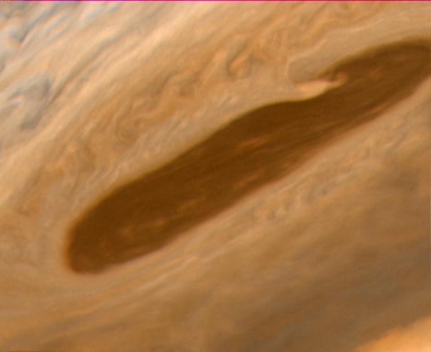 This image returned NASA Voyager 2 shows one of the long dark clouds observed in the North Equatorial Belt of Jupiter. A high, white cloud is seen moving over the darker cloud, providing an indication of the structure of the cloud layers.  At right, blue areas, free of high clouds, are seen. This photo was taken on July 6 from a distance of 3.2 million kilometers.   http://photojournal.jpl.nasa.gov/catalog/PIA00458