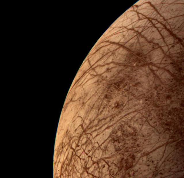 This color image of the Jovian moon Europa was acquired by NASA Voyager 2 during its close encounter on Jul. 9, 1979. Europa, the size of our moon, is thought to have a crust of ice perhaps 100 kilometers thick which overlies the silicate crust. The complex array of streaks indicate that the crust has been fractured and filled by materials from the interior. The lack of relief, any visible mountains or craters, on its bright limb is consistent with a thick ice crust. In contrast to its icy neighbors, Ganymede and Callisto, Europa has very few impact craters. One possible candidate is the small feature near the center of this image with radiating rays and a bright circular interior. The relative absence of features and low topography suggests the crust is young and warm a few kilometers below the surface. The tidal heating process suggested for Io also may be heating Europa's interior at a lower rate.  http://photojournal.jpl.nasa.gov/catalog/PIA00459