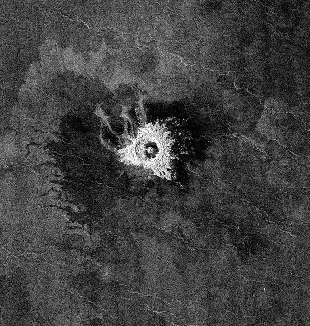 This full-resolution image from NASA Magellan spacecraft shows Jeanne crater, a 19.5 kilometer (12 mile) diameter impact crater. Jeanne crater is located at 40.0 degrees north latitude and 331.4 degrees longitude. The distinctive triangular shape of the ejecta indicates that the impacting body probably hit obliquely, traveling from southwest to northeast. The crater is surrounded by dark material of two types. The dark area on the southwest side of the crater is covered by smooth (radar-dark) lava flows which have a strongly digitate contact with surrounding brighter flows. The very dark area on the northeast side of the crater is probably covered by smooth material such as fine-grained sediment. This dark halo is asymmetric, mimicking the asymmetric shape of the ejecta blanket. The dark halo may have been caused by an atmospheric shock or pressure wave produced by the incoming body. Jeanne crater also displays several outflow lobes on the northwest side. These flow-like features may have formed by fine-grained ejecta transported by a hot, turbulent flow created by the arrival of the impacting object. Alternatively, they may have formed by flow of impact melt.   http://photojournal.jpl.nasa.gov/catalog/PIA00472