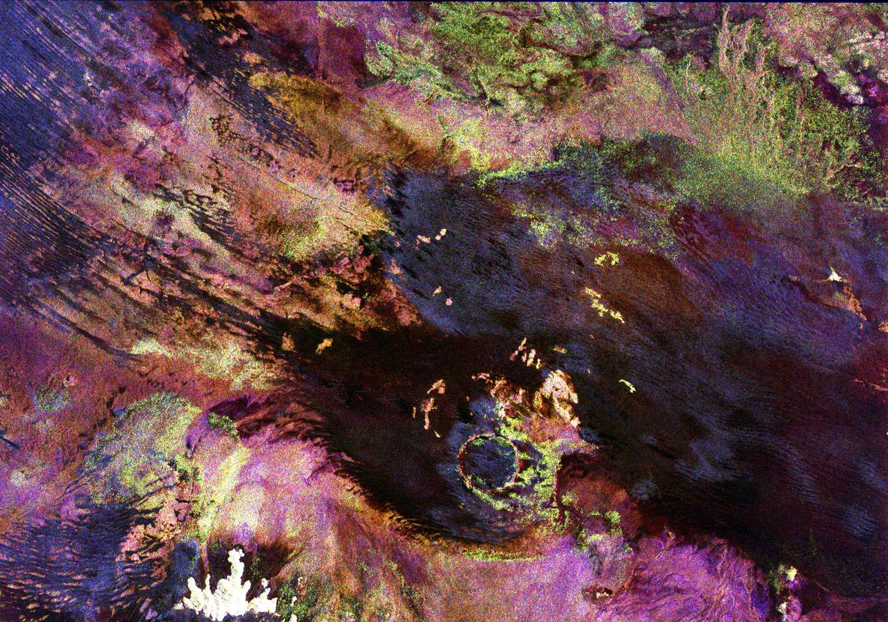 This space radar image shows the Roter Kamm impact crater in southwest Namibia. The crater rim is seen in the lower center of the image as a radar-bright, circular feature. Geologists believe the crater was formed by a meteorite that collided with Earth approximately 5 million years ago. The data were acquired by the Spaceborne Imaging Radar-C/X-Band Synthetic Aperture Radar (SIR-C/X-SAR) instrument onboard space shuttle Endeavour on April 14, 1994. The area is located at 27.8 degrees south latitude and 16.2 degrees east longitude in southern Africa. The colors in this image were obtained using the following radar channels: red represents the L-band (horizontally transmitted and received); green represents the L-band (horizontally transmitted and vertically received); and blue represents the C-band (horizontally transmitted and vertically received). The area shown is approximately 25.5 kilometers (15.8 miles) by 36.4 kilometers (22.5 miles), with north toward the lower right. The bright white irregular feature in the lower left corner is a small hill of exposed rock outcrop. Roter Kamm is a moderate sized impact crater, 2.5 kilometers (1.5 miles) in diameter rim to rim, and is 130 meters (400 feet) deep. However, its original floor is covered by sand deposits at least 100 meters (300 feet) thick. In a conventional aerial photograph, the brightly colored surfaces immediately surrounding the crater cannot be seen because they are covered by sand. The faint blue surfaces adjacent to the rim may indicate the presence of a layer of rocks ejected from the crater during the impact. The darkest areas are thick windblown sand deposits which form dunes and sand sheets. The sand surface is smooth relative to the surrounding granite and limestone rock outcrops and appears dark in radar image. The green tones are related primarily to larger vegetation growing on sand soil, and the reddish tones are associated with thinly mantled limestone outcrops. Studies of impact craters on the surface of the Earth help geologists understand the role of the impact process in the Earth's evolution, including effects on the atmosphere and on biological evolution.  http://photojournal.jpl.nasa.gov/catalog/PIA00503