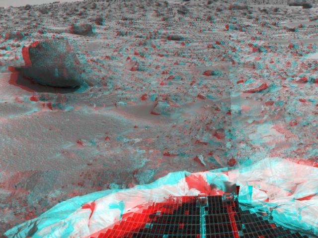 This image from NASA Mars Pathfinder shows the large rock nicknamed Yogi. Portions of a petal and deflated airbag are in the foreground. 3D glasses are necessary to identify surface detail. 