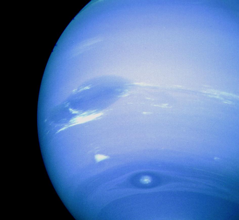 This photograph of Neptune was reconstructed from two images taken by NASA Voyager 2. At the north top is the Great Dark Spot, accompanied by bright, white clouds that undergo rapid changes in appearance.