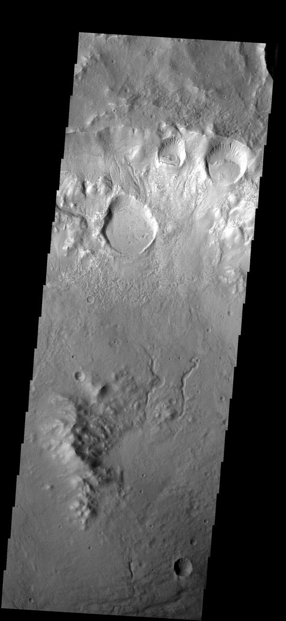 Several craters were formed on the rim of this large crater. The movement of material downhill toward the floor of the large crater has formed interesting patterns on the floors of the smaller craters
