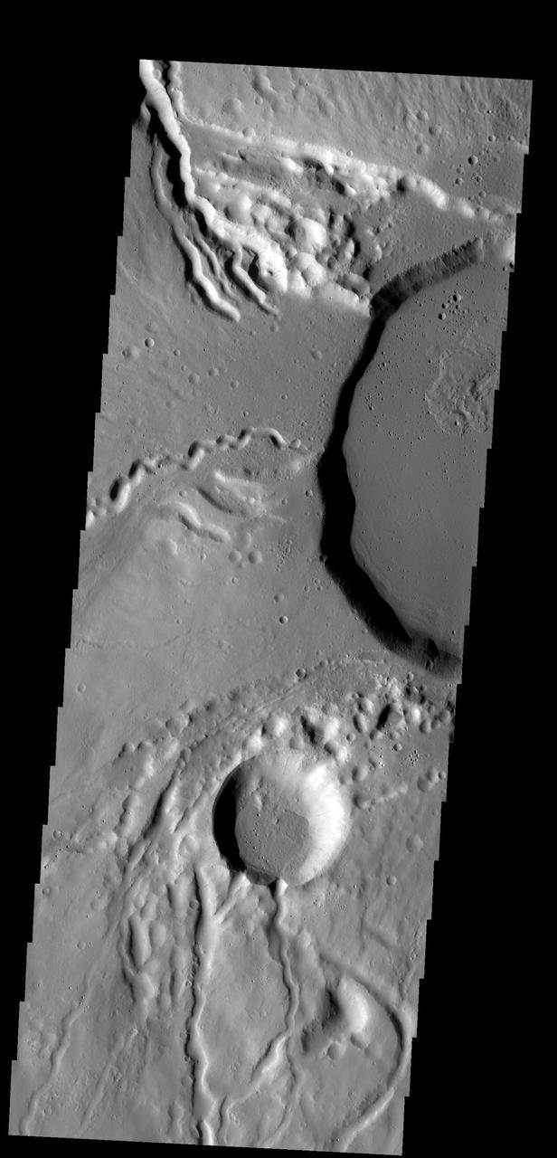This image shows part of the summit caldera of Ceraunius Tholus. Channels are common on the flanks of this volcano
