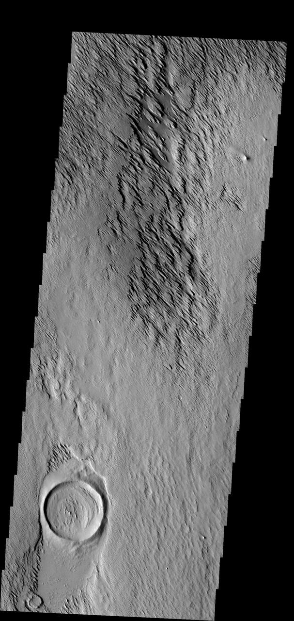 In this image the action of the wind is forming yardangs. The top layer of material is being removed by the wind, revealing an older surface below -- like the crater at the bottom of the frame. Image information: VIS instrument. Latitude 11.2N, Longitude 199.4E. 18 meter/pixel resolution. http://photojournal.jpl.nasa.gov/catalog/PIA01328