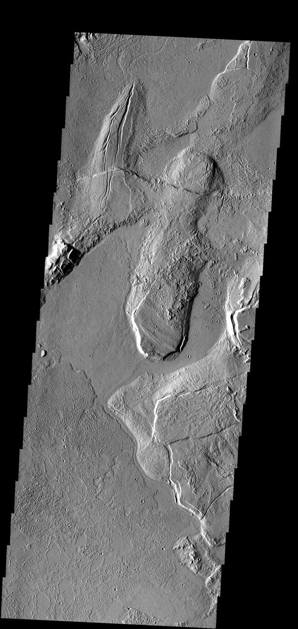 In this part of the Tharsis region, old lava flows have been fractured. Younger lava flows are unfractured flow at bottom