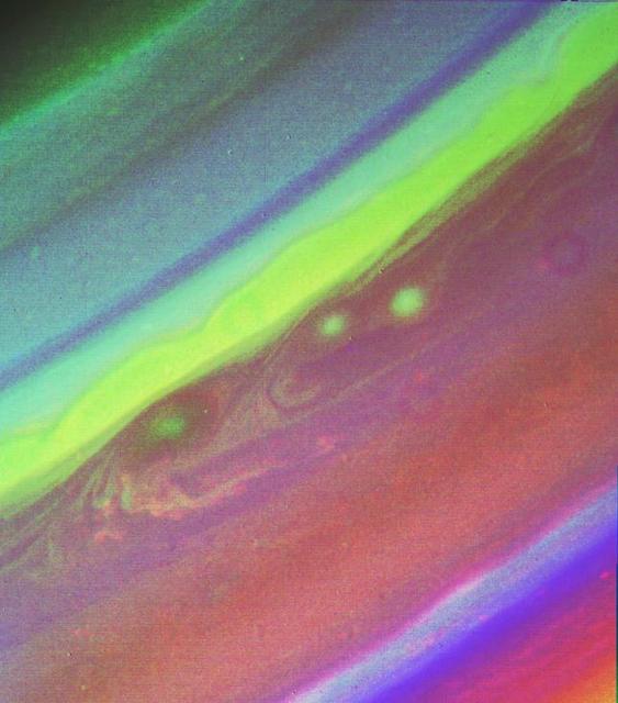 This false color picture of Saturn’s northern hemisphere was assembled from ultraviolet, violet and green images obtained Aug. 19 by Voyager 2 from a range of 7.1 million kilometers (4.4 million miles). The several weather patterns evident include three spots flowing westward at about 15 meters-per-second (33 mph). Although the cloud system associated with the western-most spot is part of this flow, the spot itself moves eastward at about 30 meters-per-second (65 mph). Their joint flow shows the anti-cyclonic rotation of the spot, which is about 3,000 km. (1,900 mi.) in diameter. The ribbon- like feature to the north marks a high-speed jet where wind speeds approach 150 meters-per-second (330 mph). http://photojournal.jpl.nasa.gov/catalog/PIA01365