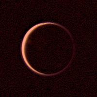 NASA Voyager 2 obtained this wide-angle image of the night side of Titan on Aug. 25, 1979. This is a view of Titan extended atmosphere. the bright orangish ring being caused by the atmosphere scattering of the incident sunlight.