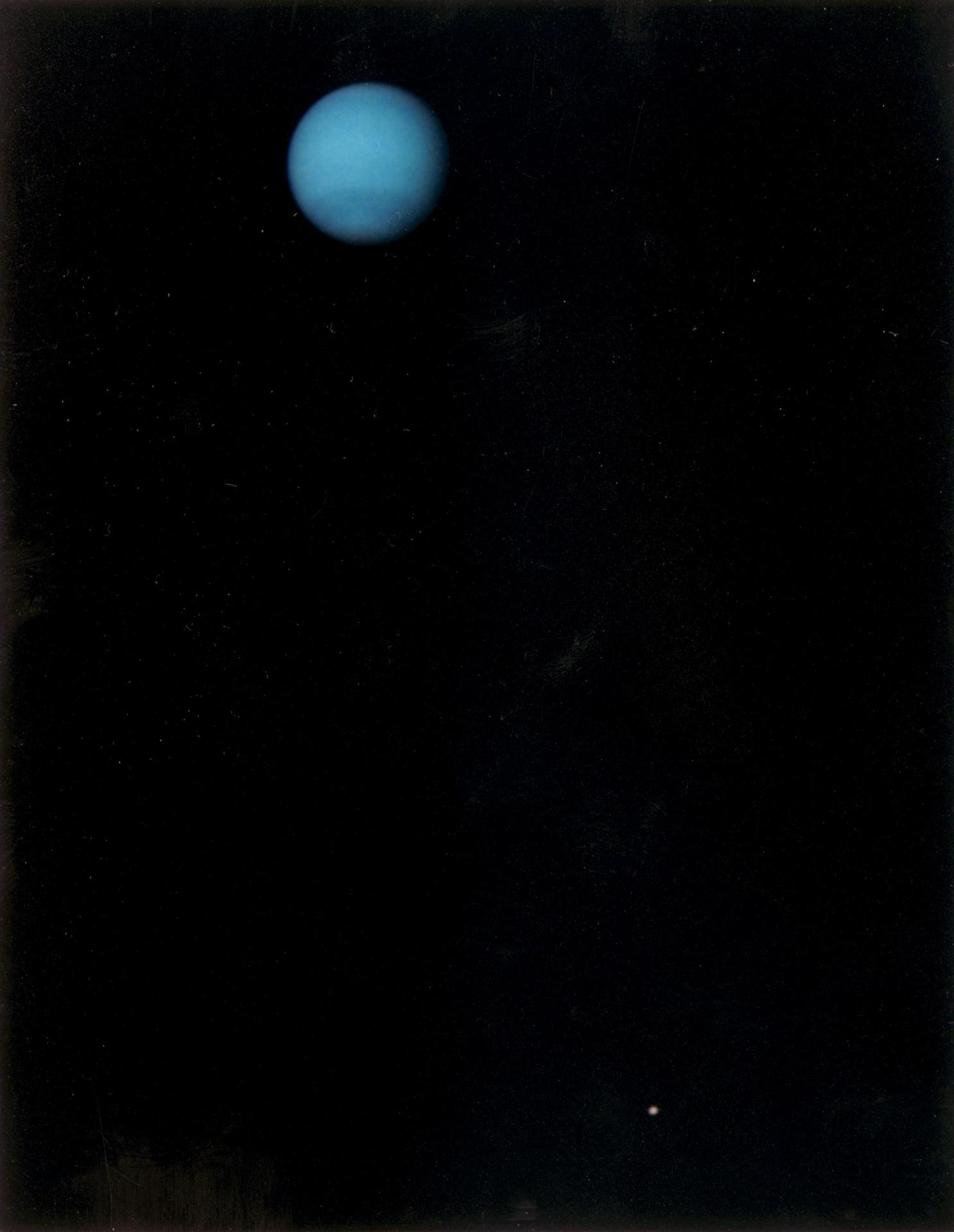 This image was returned by NASA Voyager 2 spacecraft on July 3, 1989. The planet and its largest satellite, Triton, are captured in view; Triton appears in the lower right corner at about 5 oclock relative to Neptune.