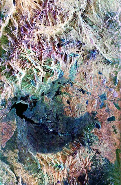 This false-color composite radar image of the Mammoth Mountain area in the Sierra Nevada Mountains, California, was acquired by the Spaceborne Imaging Radar-C and X-band Synthetic Aperture Radar aboard the space shuttle Endeavour on its 67th orbit on October 3, 1994. The image is centered at 37.6 degrees north latitude and 119.0 degrees west longitude. The area is about 39 kilometers by 51 kilometers (24 miles by 31 miles). North is toward the bottom, about 45 degrees to the right.  In this image, red was created using L-band (horizontally transmitted/vertically received) polarization data; green was created using C-band (horizontally transmitted/vertically received) polarization data; and blue was created using C-band (horizontally transmitted and received) polarization data. Crawley Lake appears dark at the center left of the image, just above or south of Long Valley. The Mammoth Mountain ski area is visible at the top right of the scene. The red areas correspond to forests, the dark blue areas are bare surfaces and the green areas are short vegetation, mainly brush. The purple areas at the higher elevations in the upper part of the scene are discontinuous patches of snow cover from a September 28 storm. New, very thin snow was falling before and during the second space shuttle pass. In parallel with the operational SIR-C data processing, an experimental effort is being conducted to test SAR data processing using the Jet Propulsion Laboratory's massively parallel supercomputing facility, centered around the Cray Research T3D. These experiments will assess the abilities of large supercomputers to produce high throughput Synthetic Aperture Radar processing in preparation for upcoming data-intensive SAR missions. The image released here was produced as part of this experimental effort.  http://photojournal.jpl.nasa.gov/catalog/PIA01746