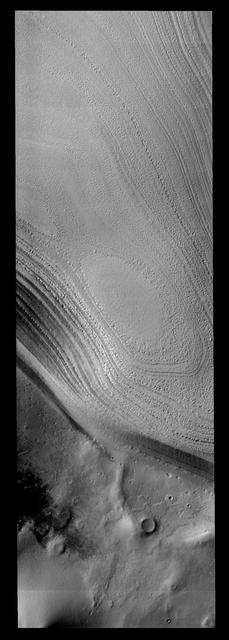 Taken during southern summer, this image from NASA 2001 Mars Odyssey spacecraft shows both the ice layers of the southern polar cap and the dusty surface that surrounds the cap.