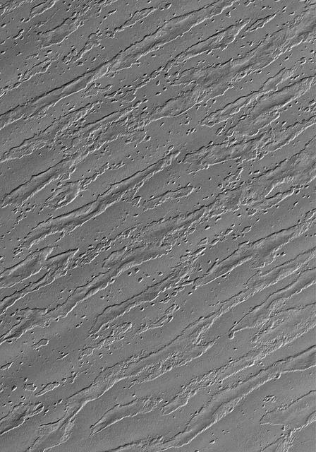 This Mars Global Surveyor MOC image shows the remains of a once more laterally extensive layer overlying undulating terrain very near the south polar residual cap