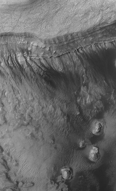 This Mars Global Surveyor MGS Mars Orbiter Camera MOC image shows gullies formed in the wall of a depression located on the floor of Rabe Crater west of the giant impact basin, Hellas Planitia