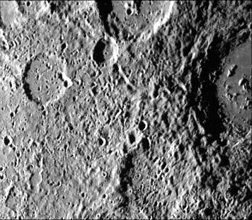 Cratered terrain very similar to that on the Moon is shown in this TV photo of Mercury taken by NASA Mariner 10. Numerous small craters and linear grooves radial to the crater can be seen.