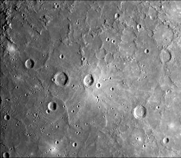 A dark, smooth, relatively uncratered area on Mercury was photographed two hours after NASA Mariner 10 flew by the planet. The prominent, sharp crater with a central peak is 30 kilometers 19 miles across.
