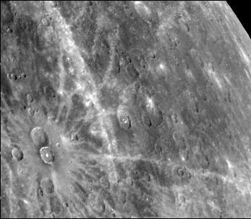 This photograph of Mercury, taken by NASA Mariner 10, shows two prominent rayed craters. Bright halos extend as far as 2 crater diameters beyond crater rims. Individual rays extend from halo.