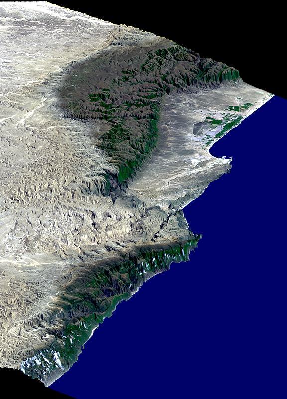This perspective view includes the city of Salalah, the second largest city in Oman. The city is located on the broad, generally bright coastal plain and includes areas of green irrigated crops.