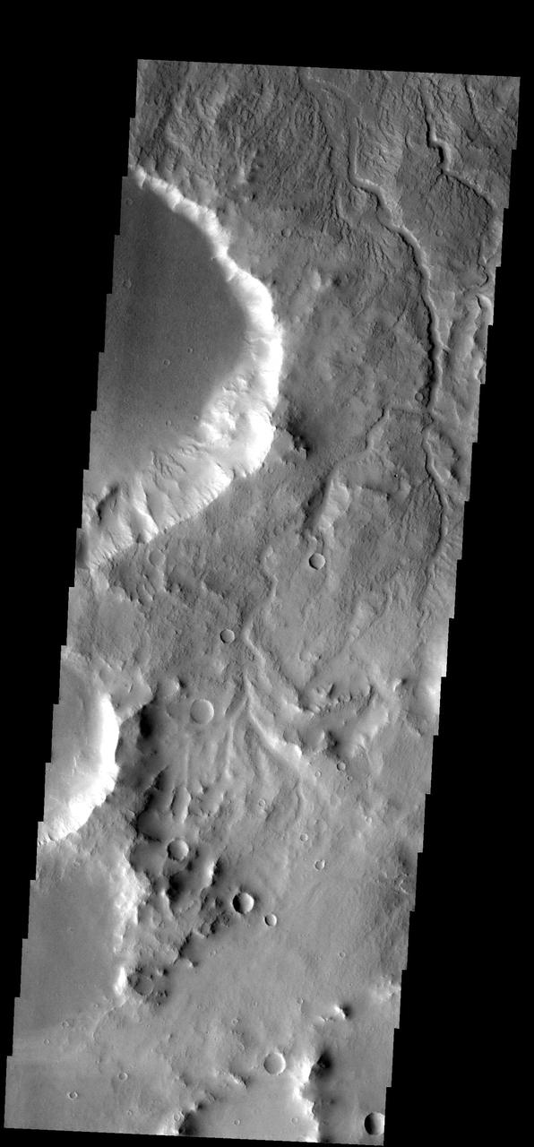 The many small channels dissecting the top part of this image are drainage  valleys. Most are draining downhill to the top [north] of the image